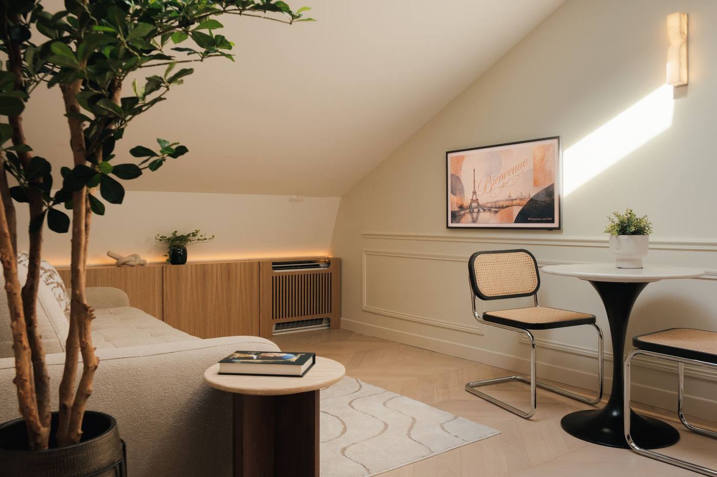 Salon mansardé d'une suite, parquet chevron et lumière naturelle