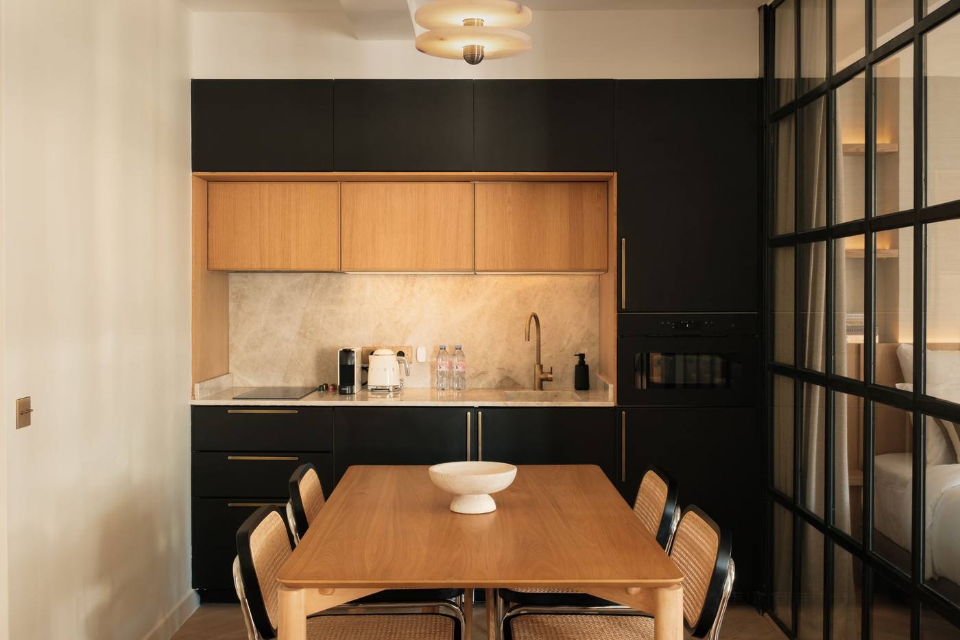 Cuisine noire et table en chêne, vue depuis le séjour