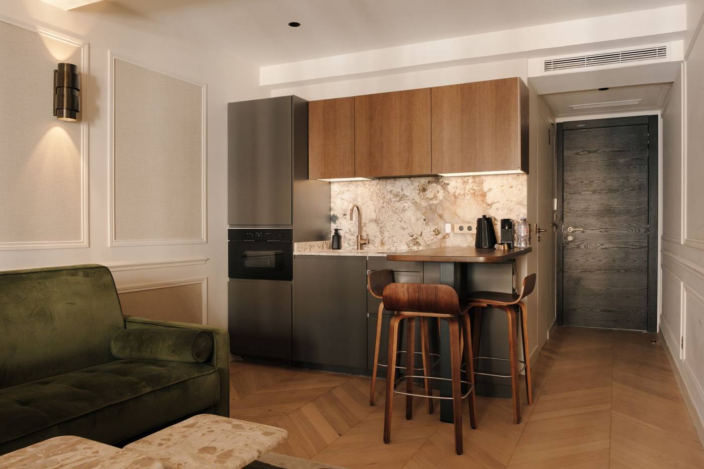 Suite 03: cucina a vista, bancone e divano in velluto verde
