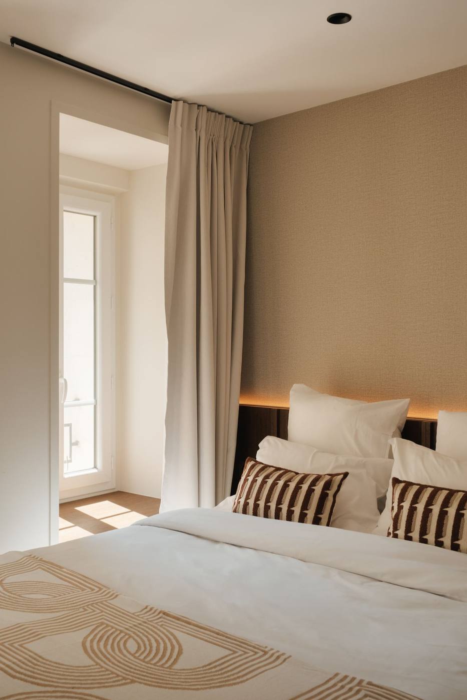 Chambre au couvre-lit graphique et chevets en chêne
